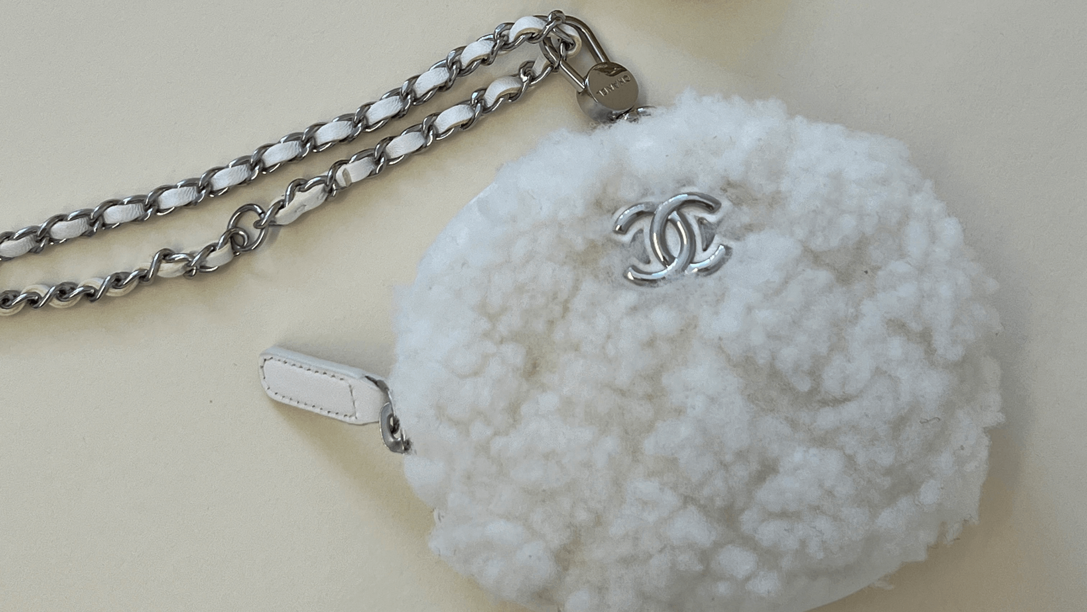 White textured round Chanel bag with a chain strap