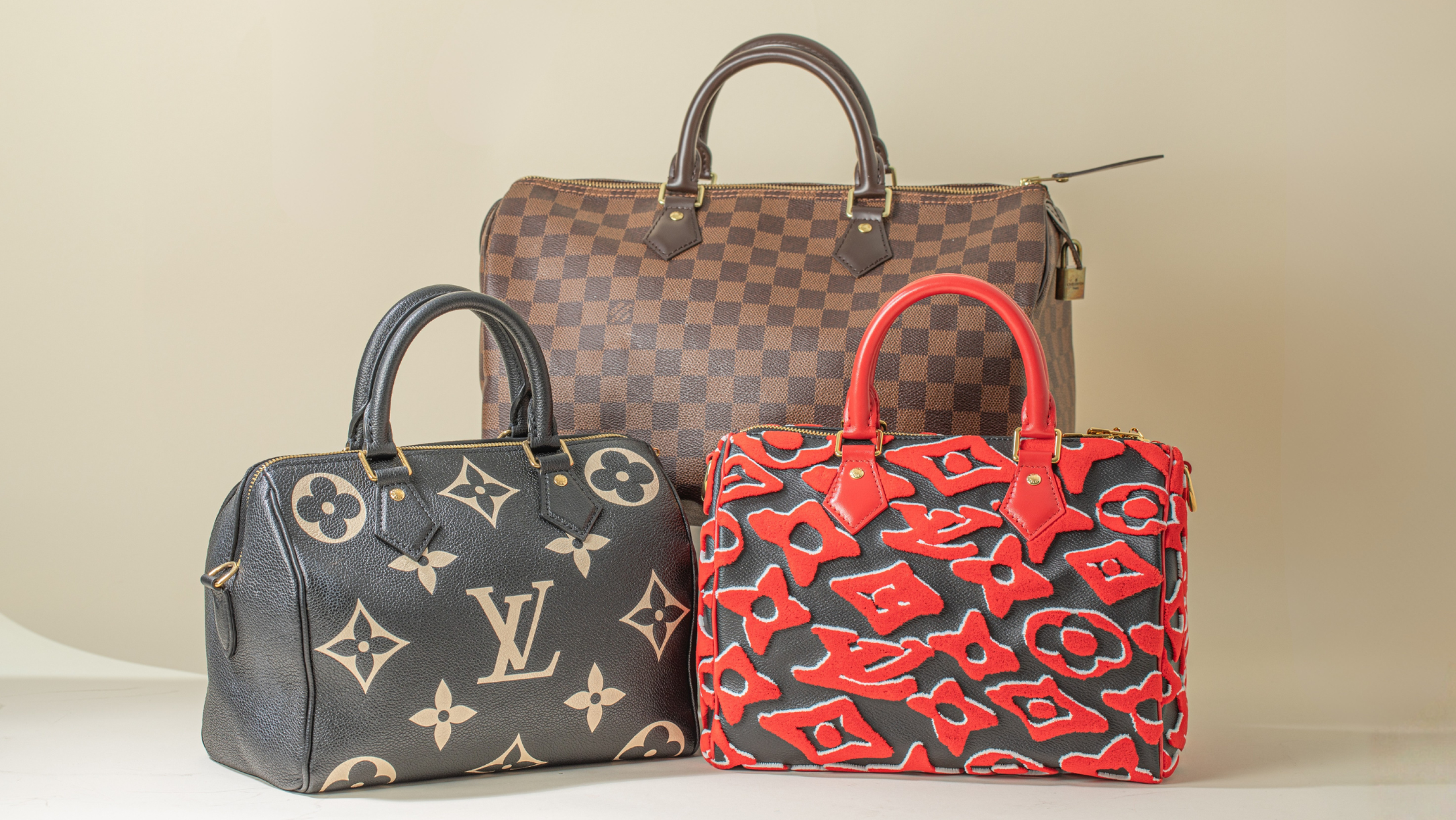 Three Louis Vuitton Speedy Bags on beige background
