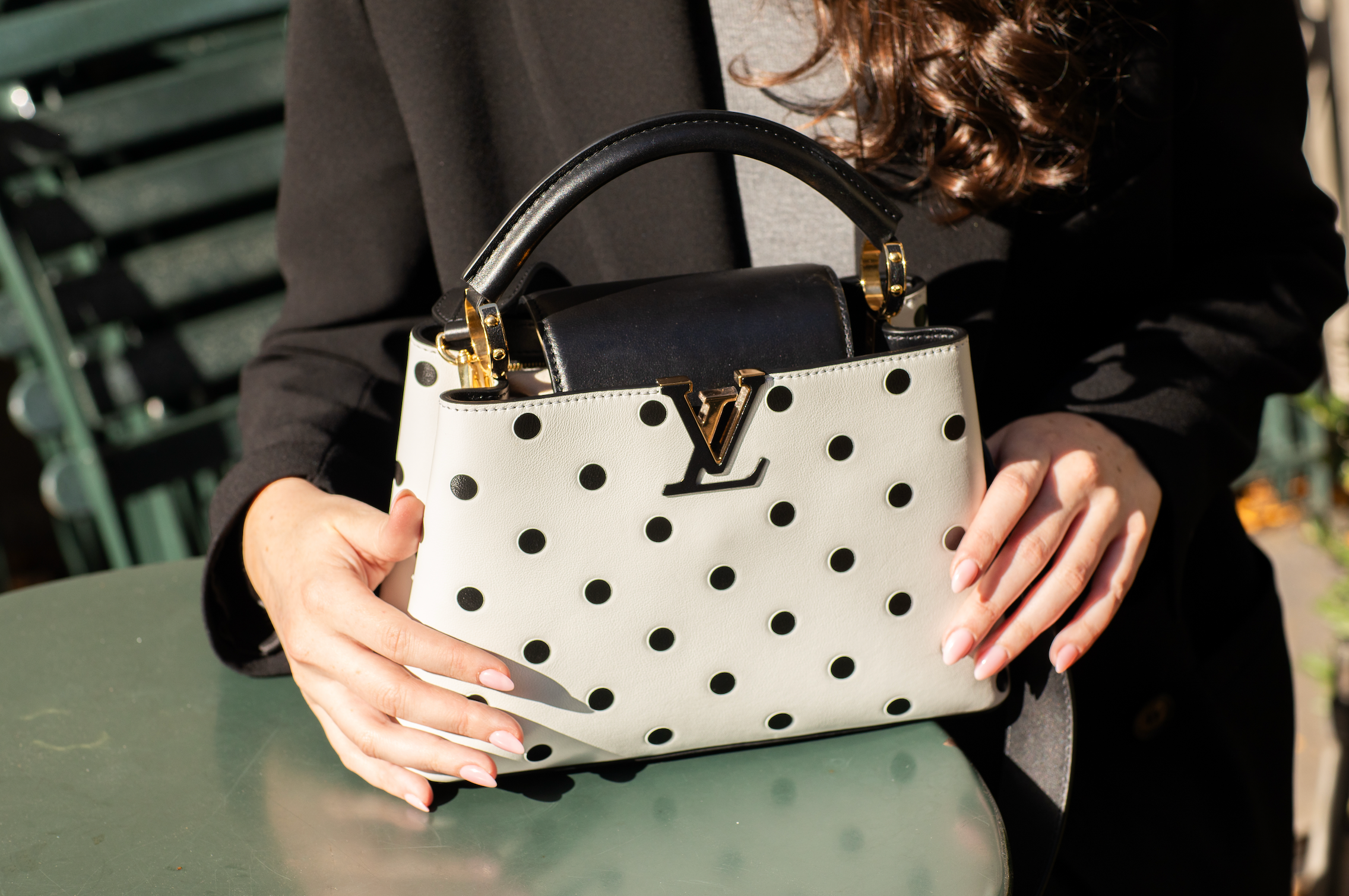 woman holding a black and white louis vuitton bag